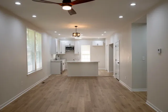 a view of a kitchen with wooden floor a sink and windows