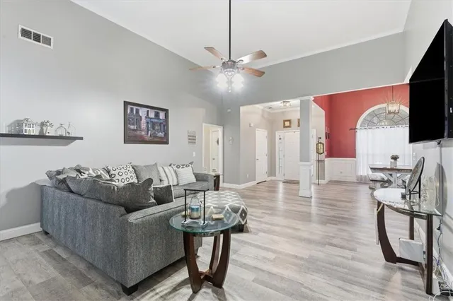 a living room with furniture a flat screen tv and a table
