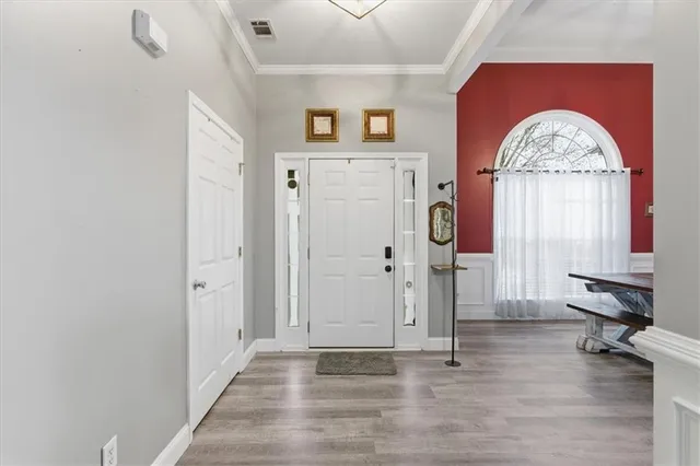 a view of a livingroom with wooden floor and a chandelier