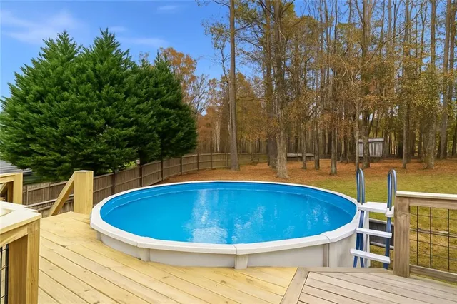 a view of swimming pool with sitting area and trees around