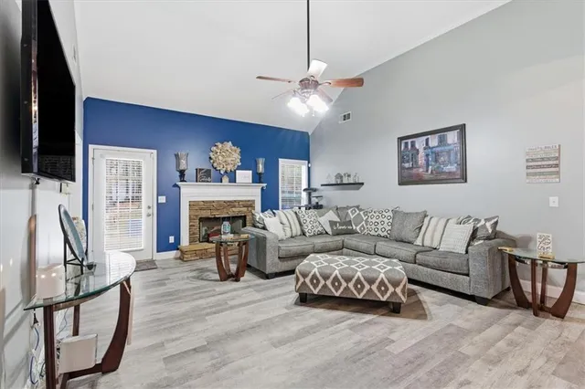 a living room with furniture a fireplace and a flat screen tv