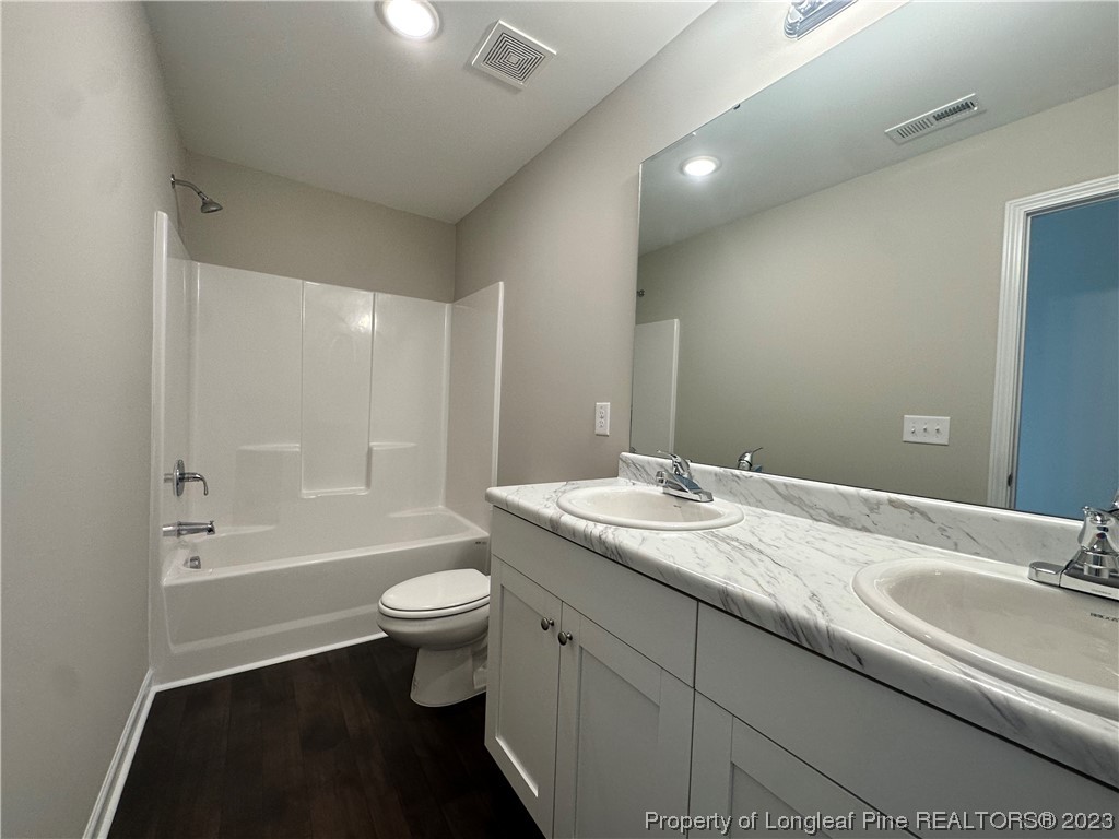 757 Britt Road St. Pauls, NC 28384 - Photo 18 of 25 a bathroom with a granite countertop sink a toilet a shower and a mirror