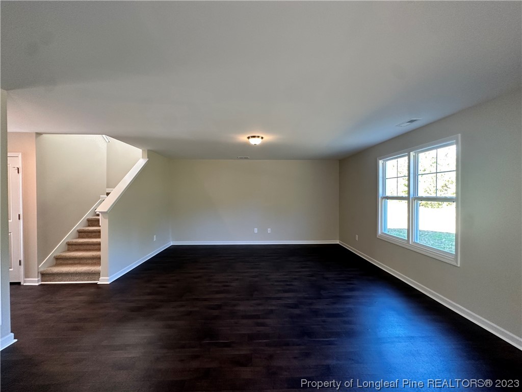 757 Britt Road St. Pauls, NC 28384 - Photo 2 of 25 a view of an empty room with wooden floor and fan