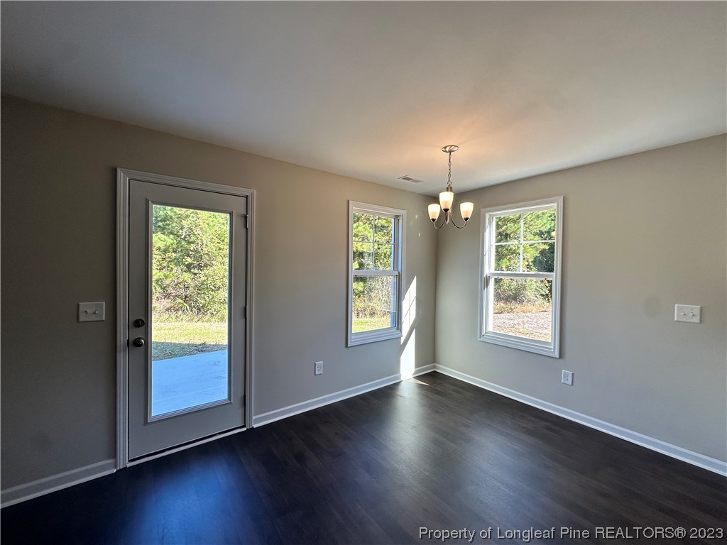 757 Britt Road St. Pauls, NC 28384 - Photo 6 of 25 an empty room with wooden floor and windows