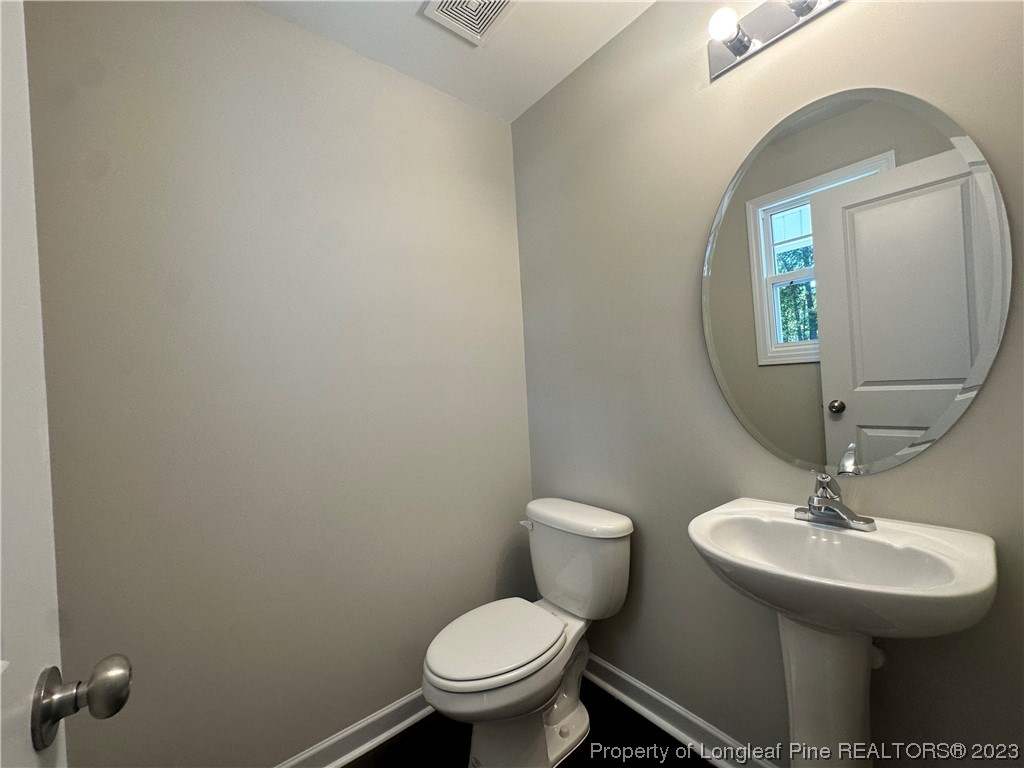 757 Britt Road St. Pauls, NC 28384 - Photo 8 of 25 a bathroom with a toilet a sink and mirror