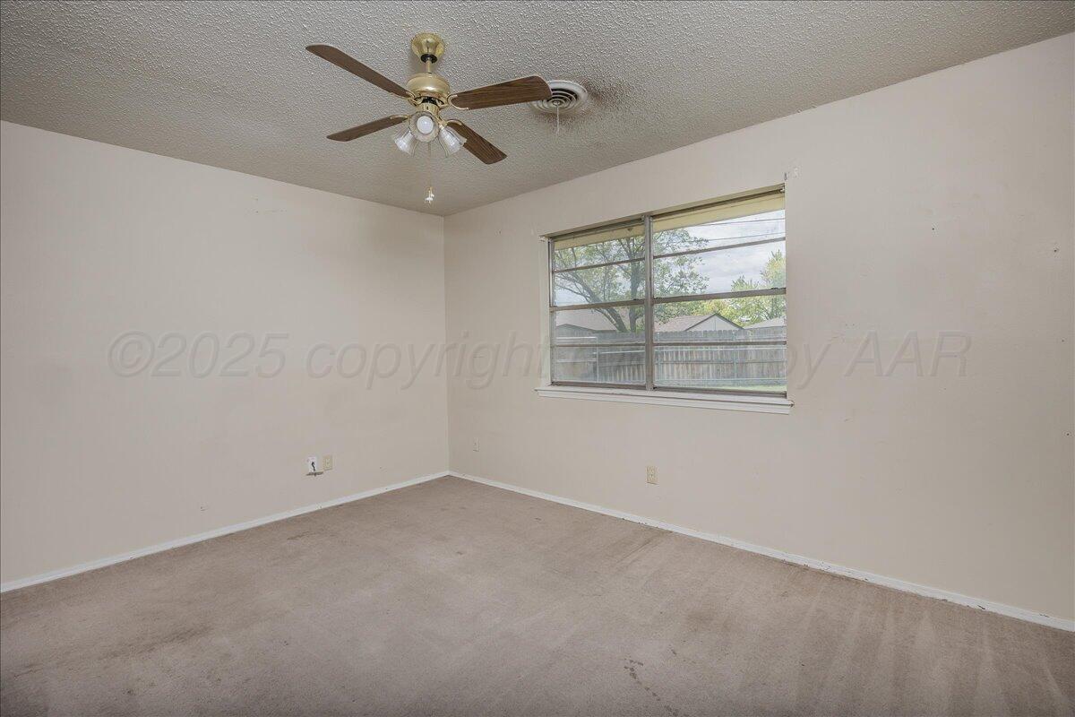 7209 Hatton Road Amarillo, TX 79110 - Photo 11 of 16 an empty room with a window and a fan