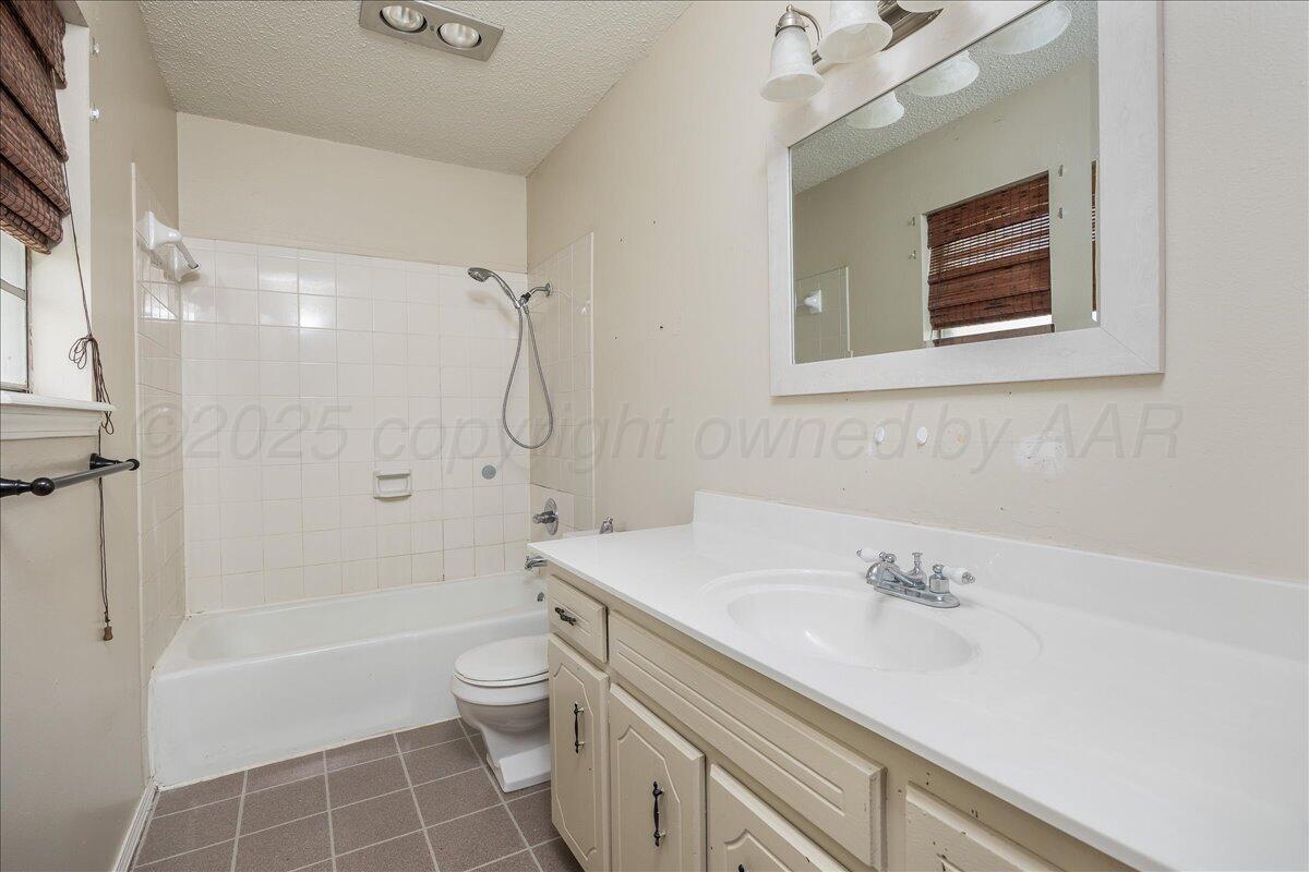 7209 Hatton Road Amarillo, TX 79110 - Photo 13 of 16 a bathroom with a sink a toilet and shower