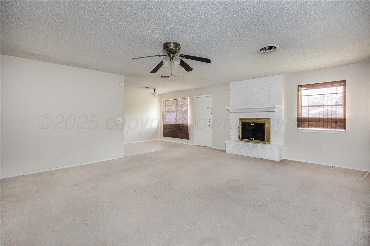 7209 Hatton Road Amarillo, TX 79110 - Photo 3 of 16 a view of empty room with a fireplace