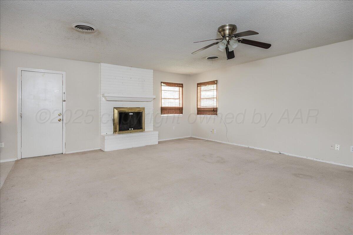 7209 Hatton Road Amarillo, TX 79110 - Photo 4 of 16 a view of a livingroom with a fireplace and a ceiling fan