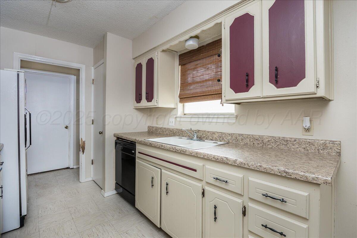 7209 Hatton Road Amarillo, TX 79110 - Photo 7 of 16 a kitchen with granite countertop a sink and cabinets