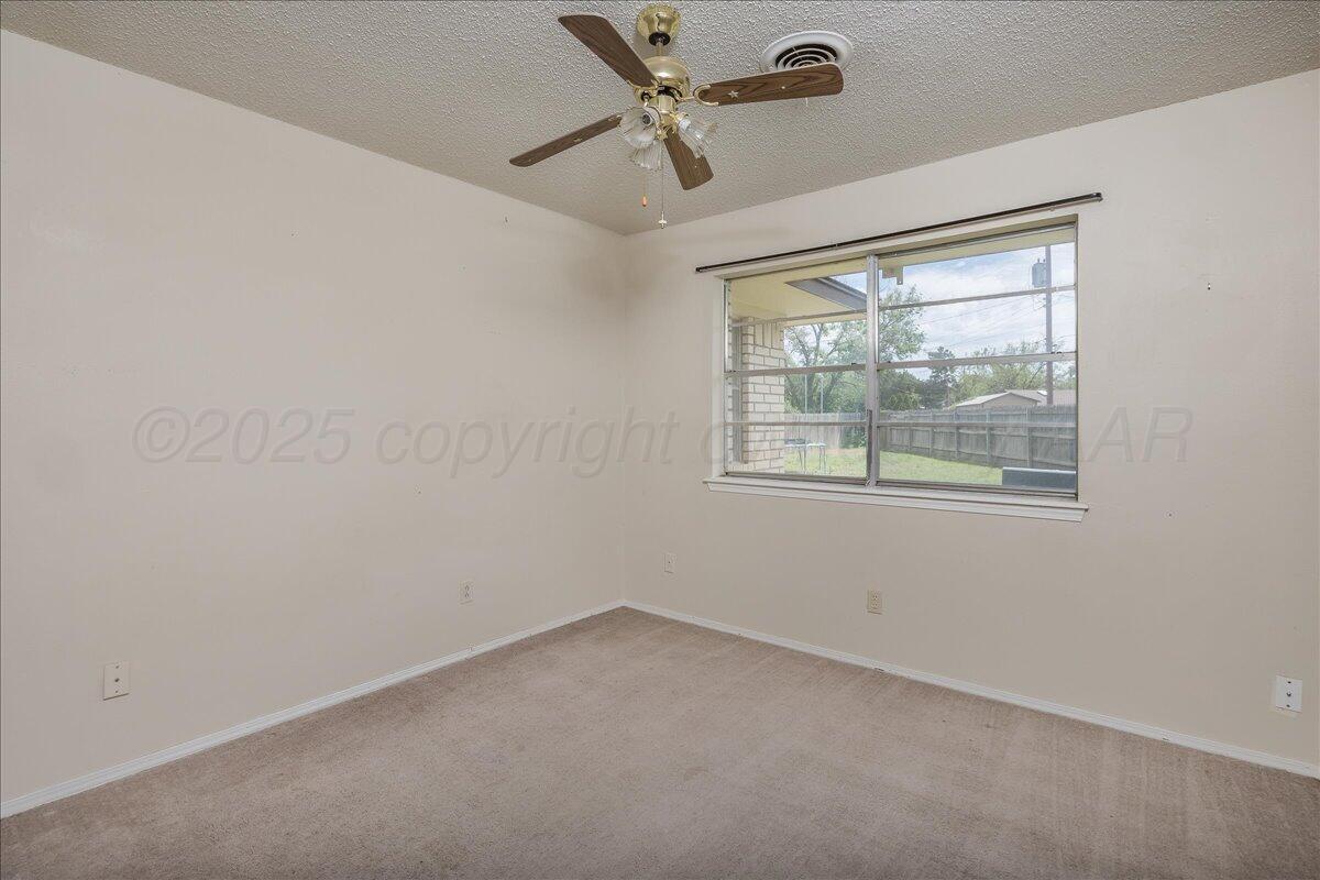 7209 Hatton Road Amarillo, TX 79110 - Photo 9 of 16 an empty room with windows and ceiling fan