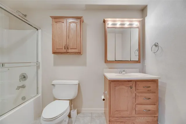 a bathroom with a toilet a sink a bath tub and mirror