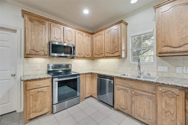 a kitchen with stainless steel appliances granite countertop a sink stove and microwave