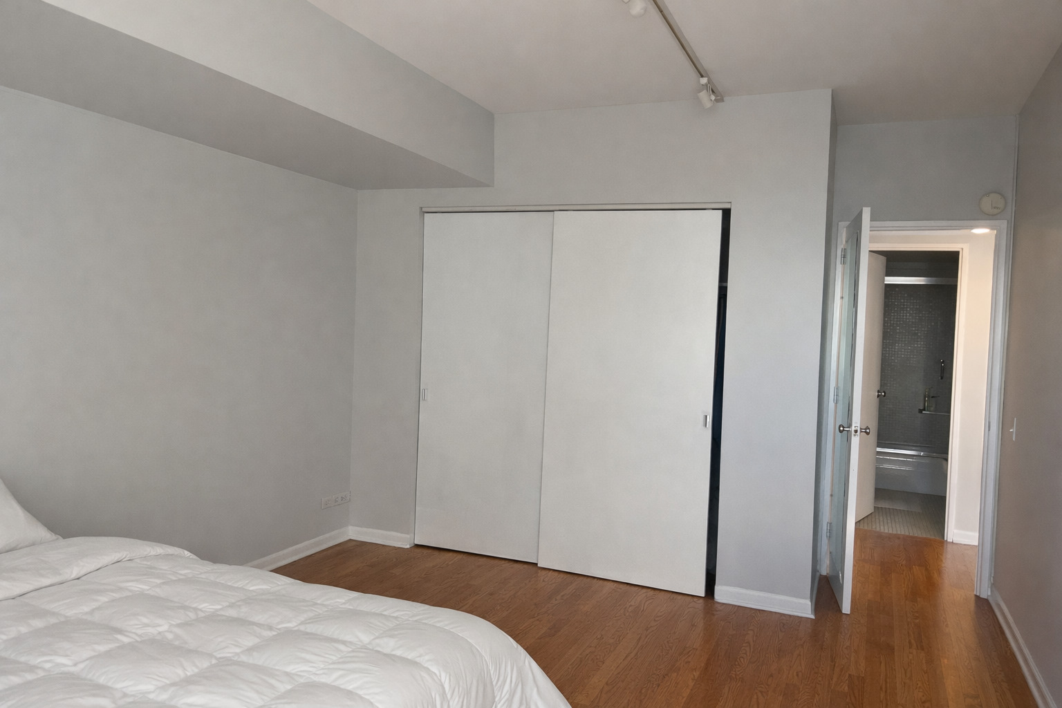 175 East Delaware Place, Unit 6114 Chicago, IL 60611 - Photo 11 of 16 a bedroom with a bed and wooden floor
