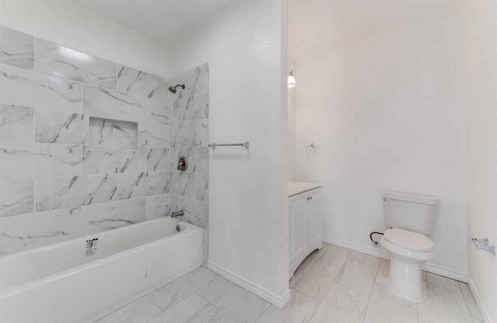 2003 Walnut Street Greenville, TX 75401 - Photo 13 of 18 a bathroom with a toilet and shower