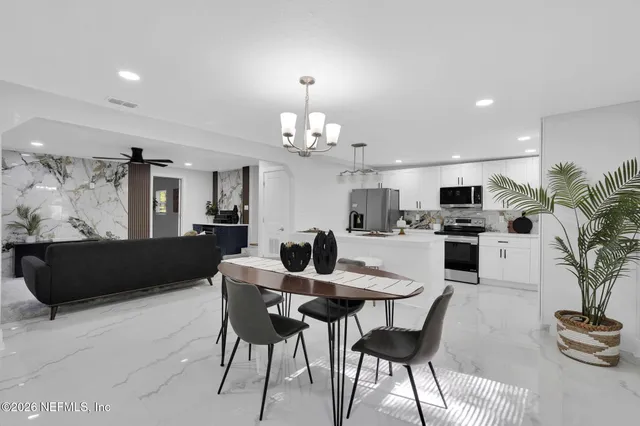 a view of a dining room with furniture and chandelier