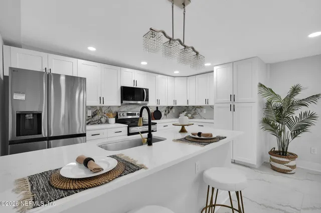 a kitchen with sink refrigerator stove and microwave