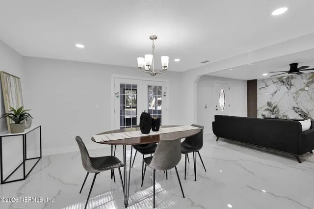 a view of a dining room with furniture and chandelier