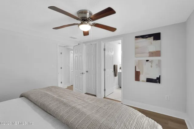 a view of a bedroom with a bed and a ceiling fan