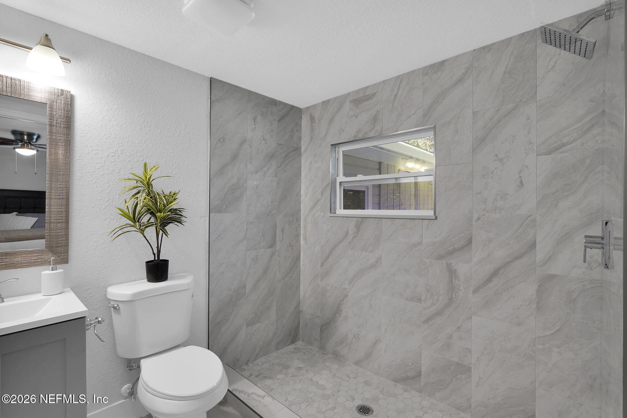 3946 Murrhee Road Green Cove Springs, FL 32043 - Photo 27 of 35 a bathroom with a toilet a sink a shower and a window