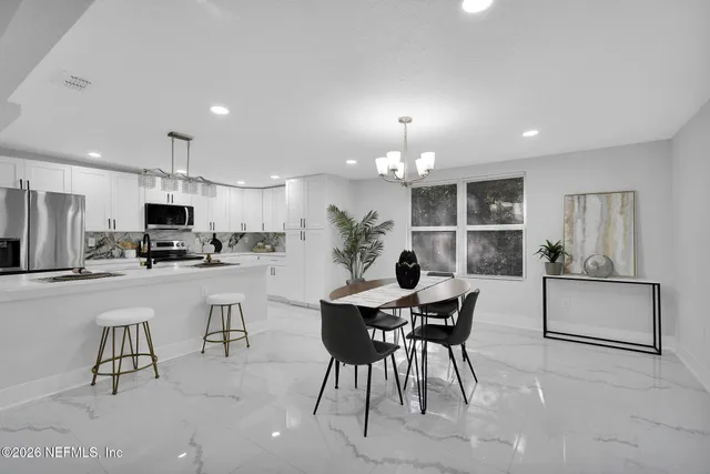 a view of a dining room with furniture and a kitchen view