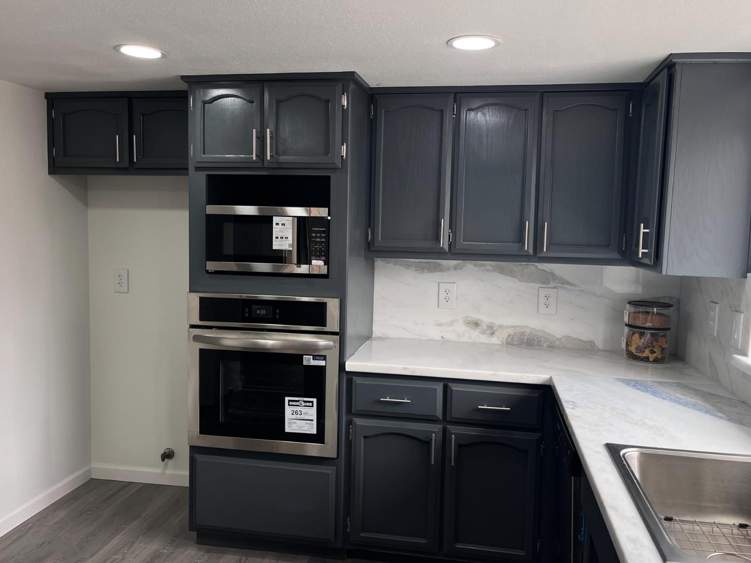 929 Barnett Way Madera, CA 93637 - Photo 11 of 23 a kitchen with kitchen island granite countertop stainless steel appliances and wooden cabinets