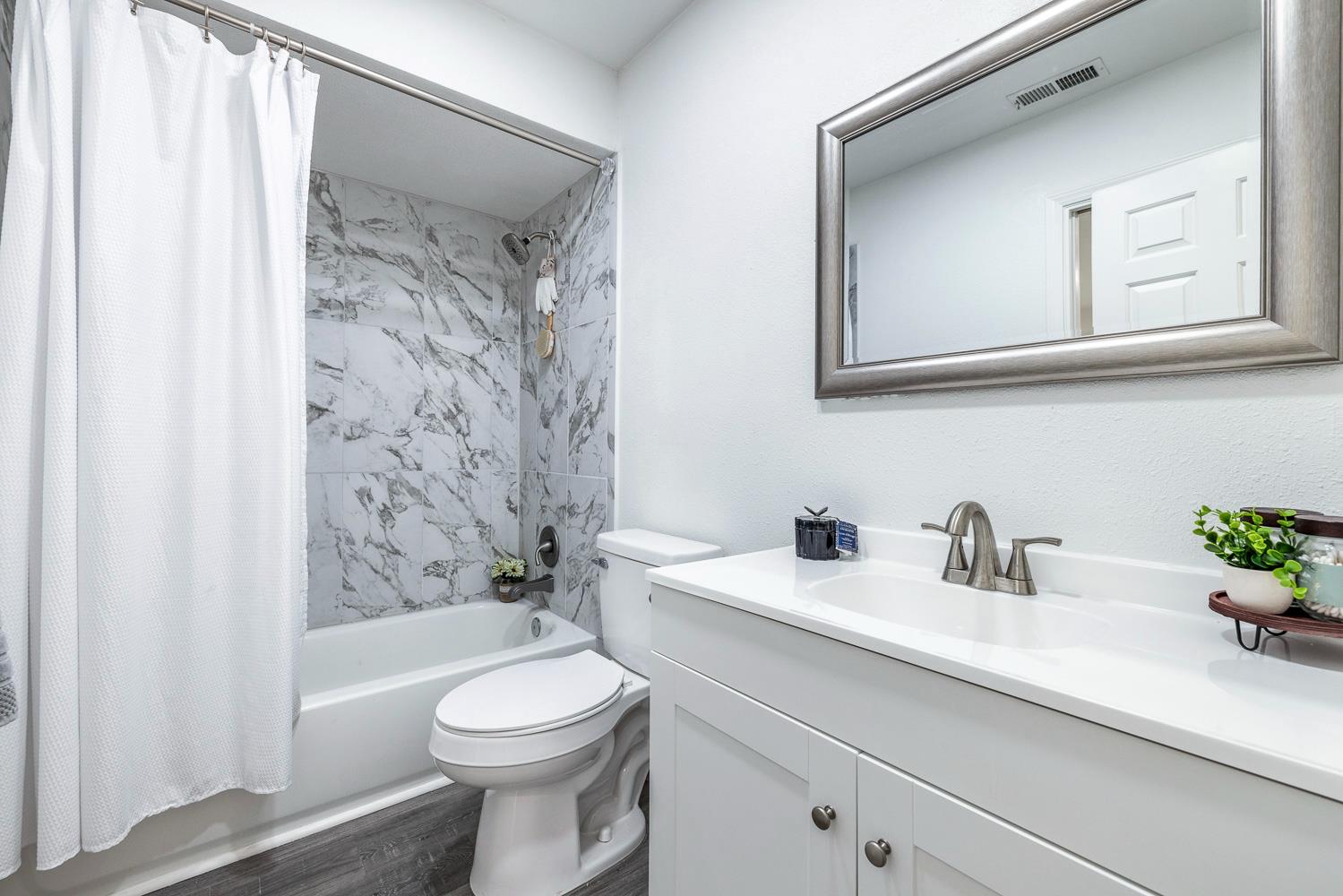 929 Barnett Way Madera, CA 93637 - Photo 14 of 23 a bathroom with a sink a toilet and a mirror