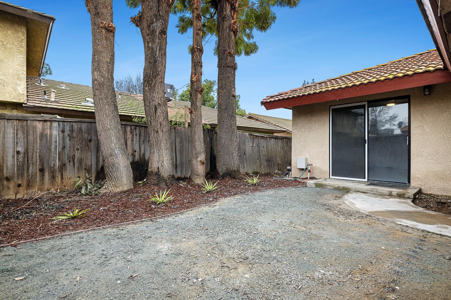 929 Barnett Way Madera, CA 93637 - Photo 21 of 23 a view of a house with a tree and wooden fence