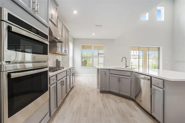 a kitchen with stainless steel appliances granite countertop a stove and a sink