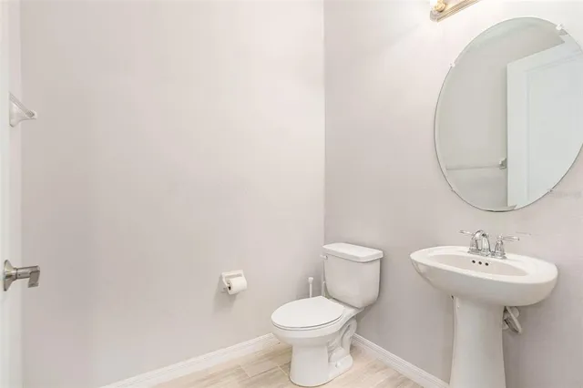 a bathroom with a sink toilet and a mirror