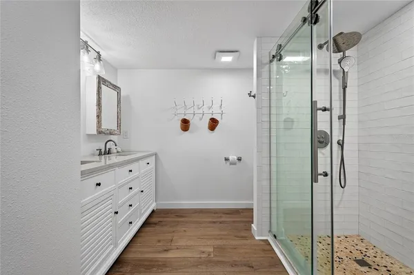 a bathroom with a shower sink and mirror