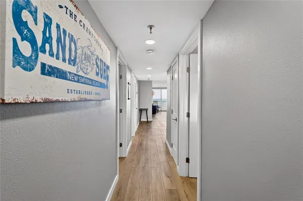 a view of a hallway with wooden floor and entryway