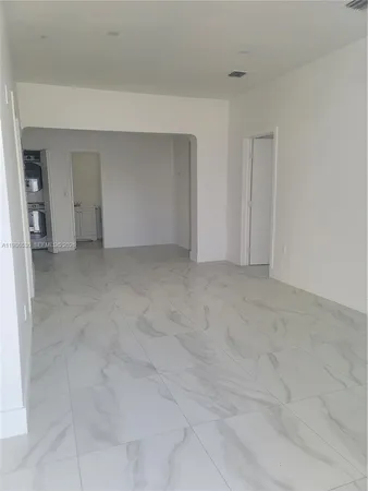 a view of an empty room with closet and entryway