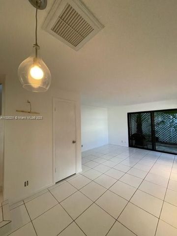 a view of an empty room with wooden floor and cabinet