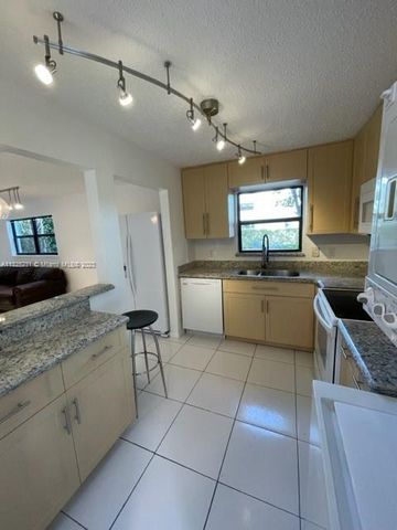 a kitchen with a sink a counter top space appliances and cabinets