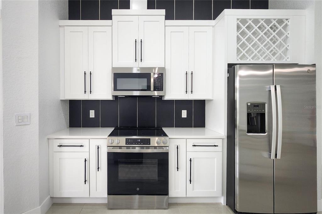 7027 Frascati Loop Wesley Chapel, FL 33544 - Photo 3 of 28 a kitchen with stainless steel appliances a refrigerator stove and microwave