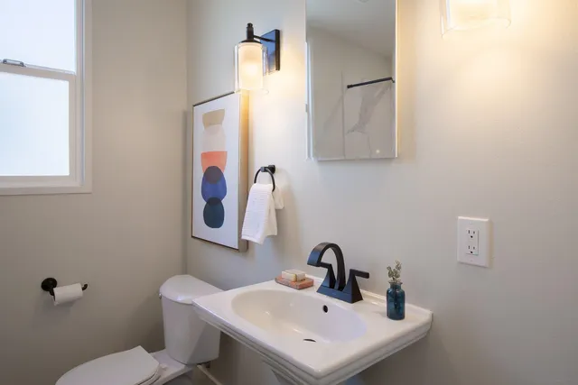 a bathroom with a toilet sink and mirror