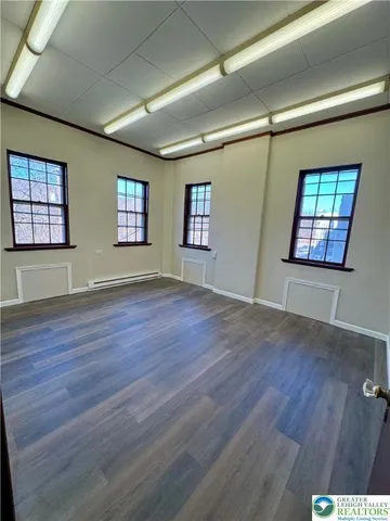 a large kitchen with a large window stainless steel appliances and wooden floor