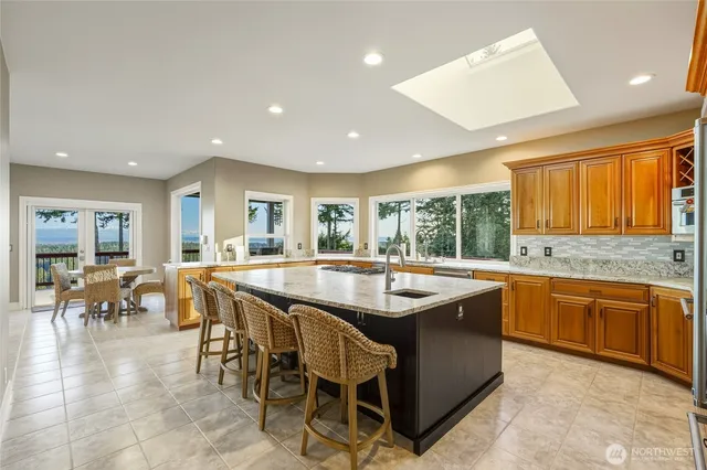 a dining hall with stainless steel appliances granite countertop lots of counter top space and furniture