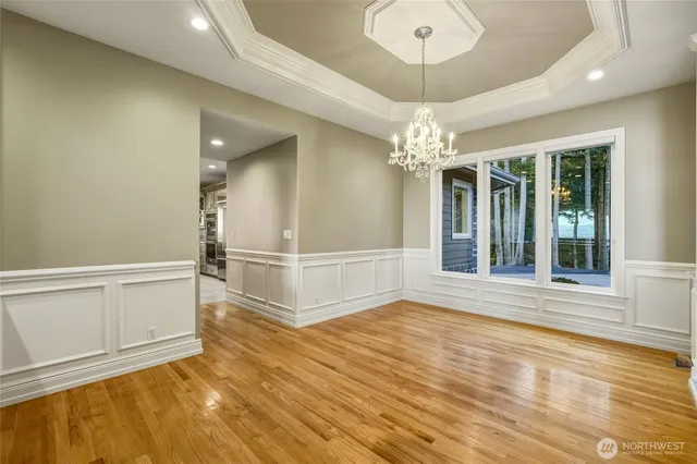 en empty room with a window and chandelier