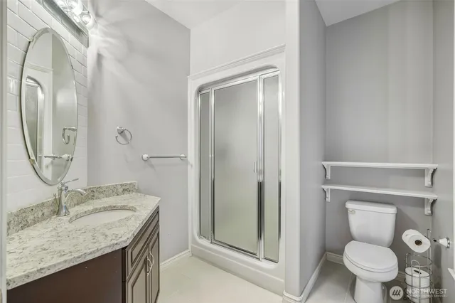 a bathroom with a granite countertop sink toilet and shower