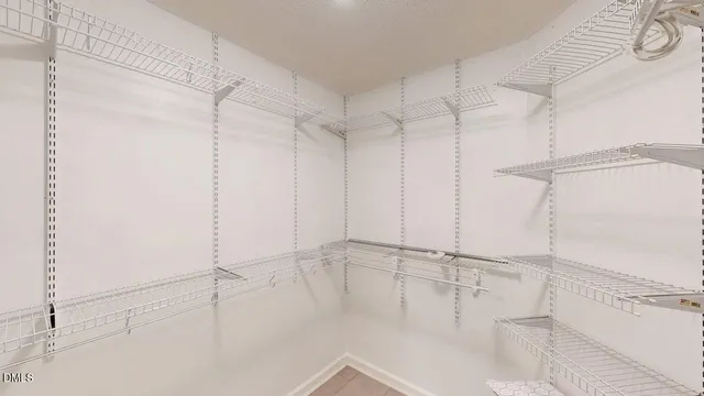 an empty room with wooden floor closet and windows