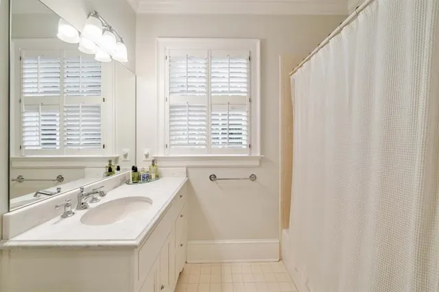 a bathroom with a sink double vanity granite tub shower and a mirror