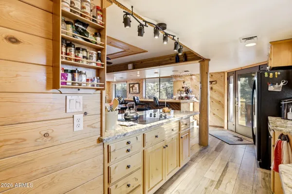 a kitchen with a stove a refrigerator and a dining table with wooden floor