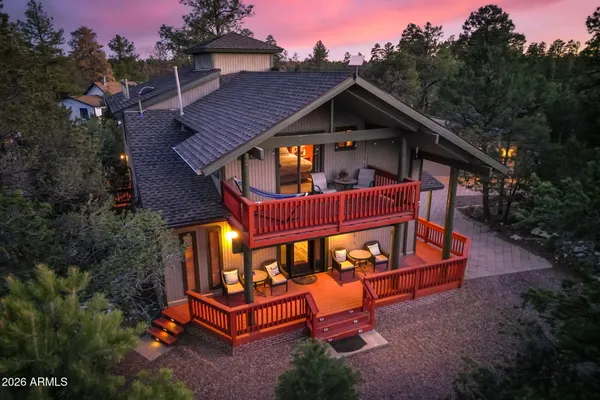 a view of a house with a yard outdoor seating area and trees