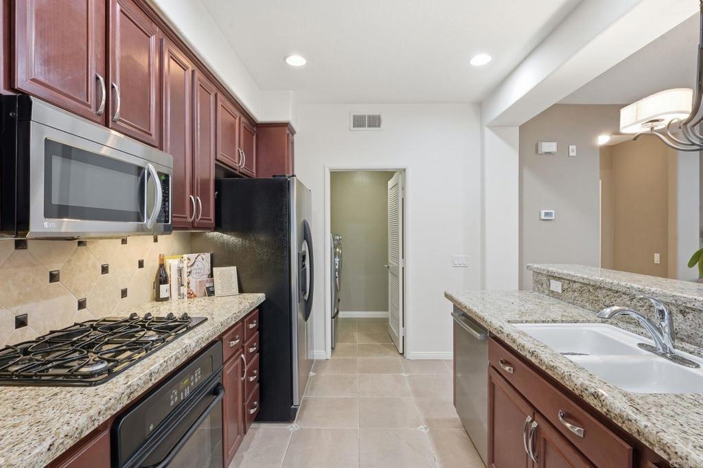 60 Via Sovana Santee, CA 92071 - Photo 9 of 26 a kitchen with stainless steel appliances granite countertop a stove a sink dishwasher a refrigerator and a microwave