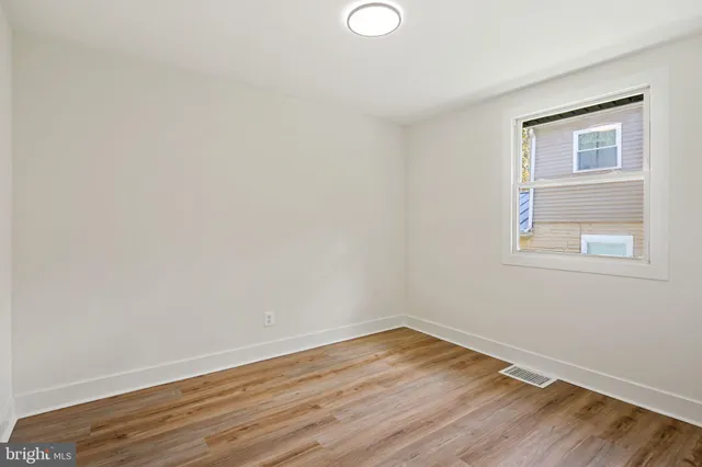 a view of a room with wooden floor and white walls