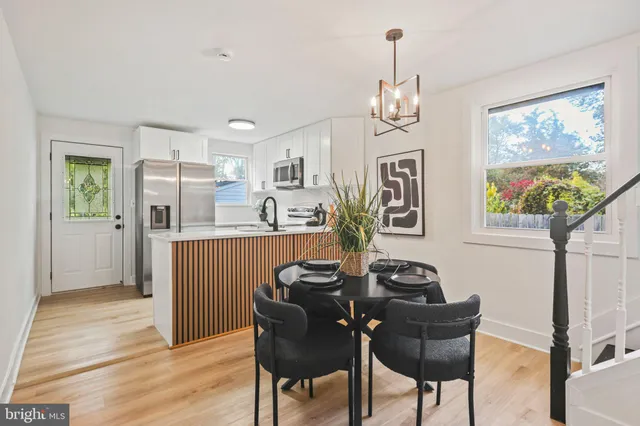 a view of a dining room with furniture a chandelier and wooden floor