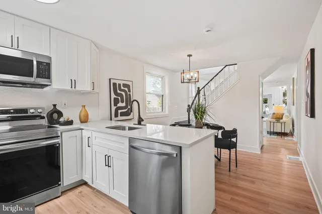 a kitchen with a sink stove and wooden floor