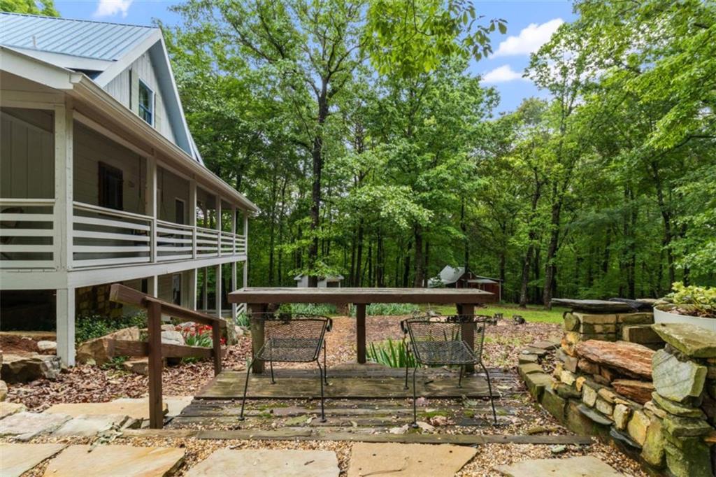 219 Raven Cliff Road Talking Rock, GA 30175 - Photo 56 of 77 a view of a patio with table and chairs with wooden floor and fence